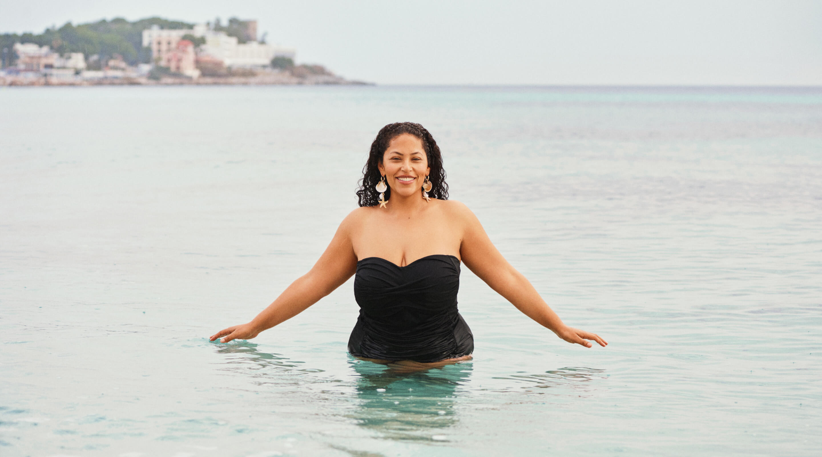Le mannequin en haut de bikini blanc au bord du port avec des nageurs